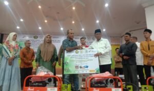 Anggota DPR - RI Anwar Idris komisi VII yang menggunakan baju putih dua dari kanan menyerahkan bantuan mesin pompa air kepada masyarakat di gedung ACC Tingket Kota Lhokseumawe, Jum' at, 20 Oktober 2023.